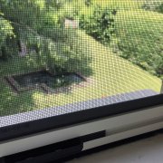 Détail d'une moustiquaire verticale sur fenêtre